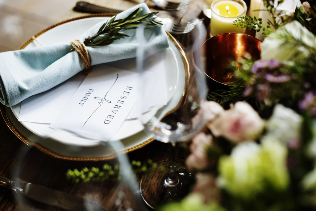 Tischdeko auf einem reservierten Tisch mit Kerzen und Blumen in der Trauerfeier Location Café Schauburg Duderstadt